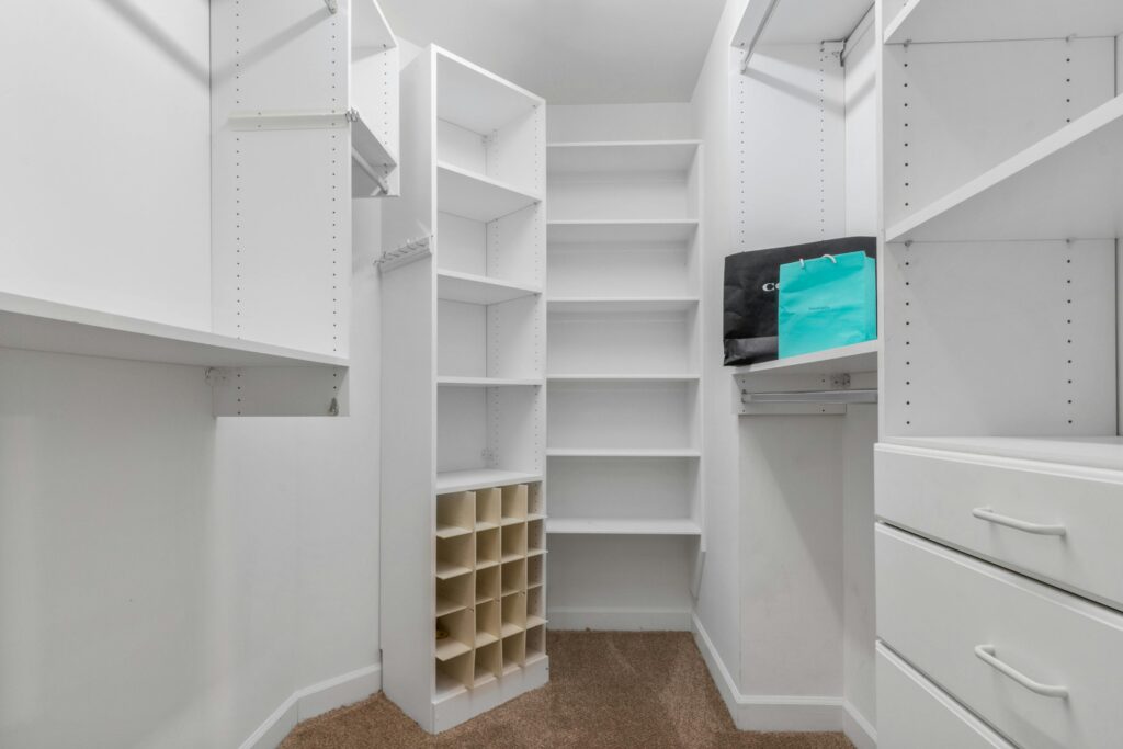 Explore a spacious white closet interior featuring shelves, drawers, and a clean design ideal for modern living.