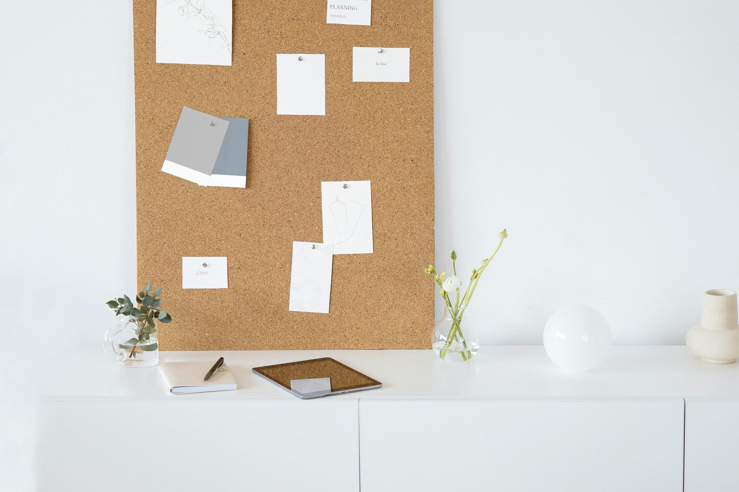 Bright and modern minimalist workspace with cork board for inspiration and creativity.